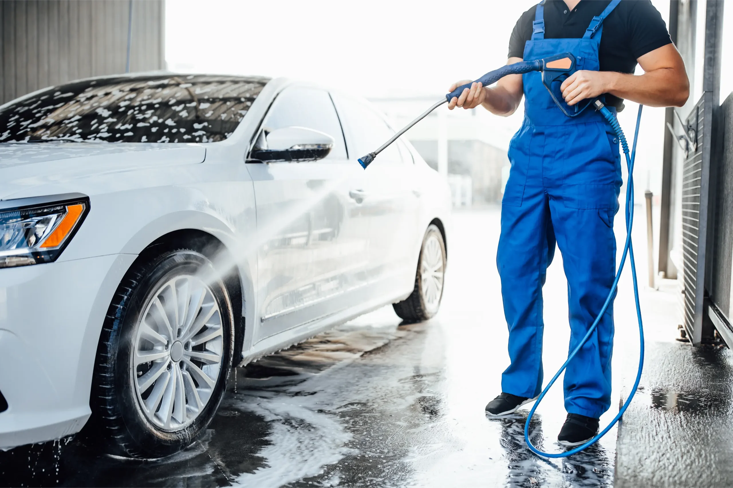 professional washer blue uniform washing luxury car with water gun open air car wash scaled